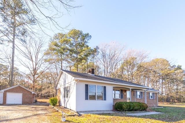 view of front of home with a garage, an outbuilding, and a front lawn