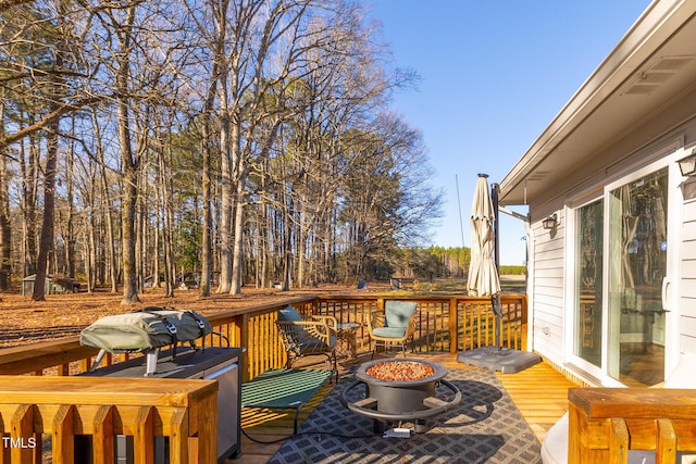 wooden deck featuring an outdoor fire pit