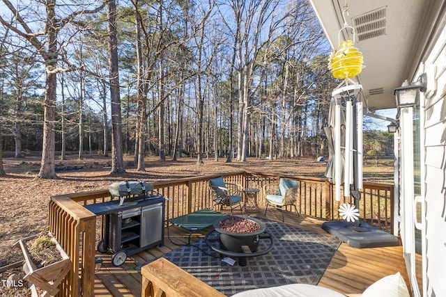 wooden deck with an outdoor fire pit