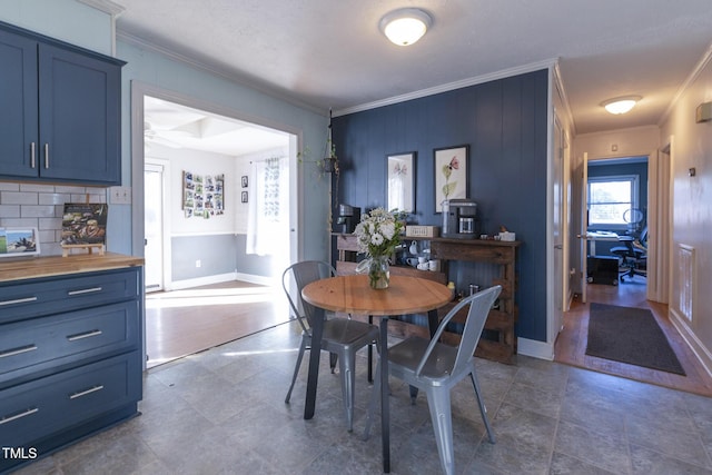 dining room with ceiling fan and crown molding