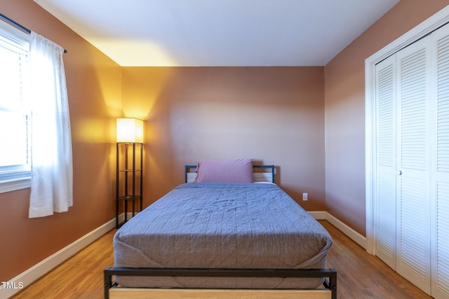 bedroom with hardwood / wood-style floors and a closet