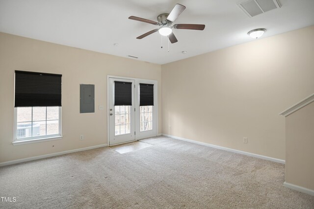 empty room with electric panel, ceiling fan, and light carpet