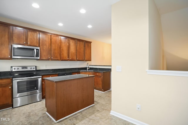 kitchen featuring stainless steel appliances, a kitchen island, dark stone counters, and sink