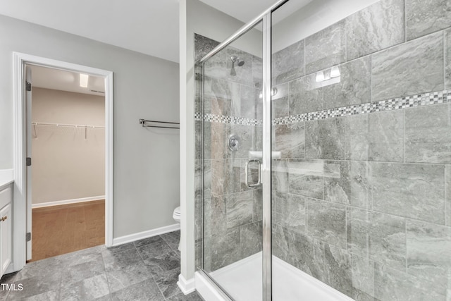 bathroom featuring toilet, vanity, and walk in shower