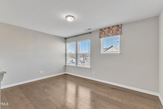 empty room with dark hardwood / wood-style flooring