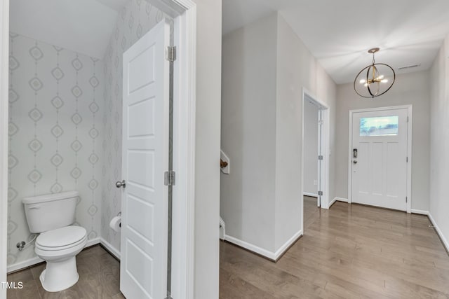 foyer entrance featuring light hardwood / wood-style floors and an inviting chandelier