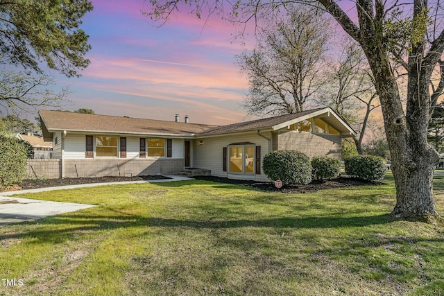 single story home featuring a lawn