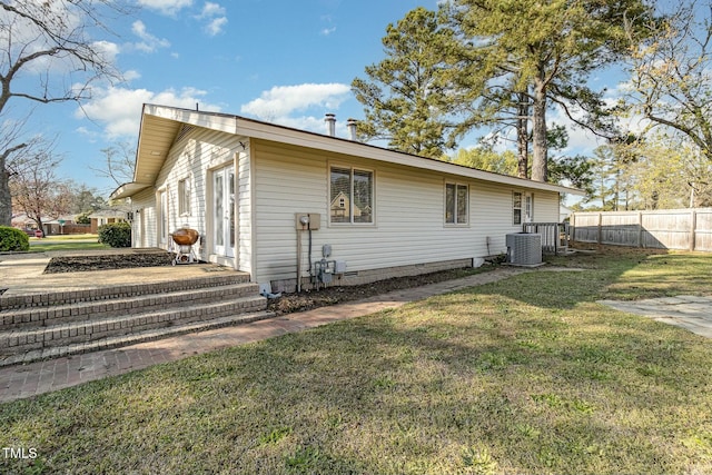 view of side of property featuring a yard and central AC