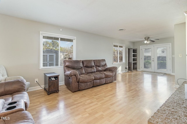 living room featuring french doors, light wood-type flooring, and ceiling fan