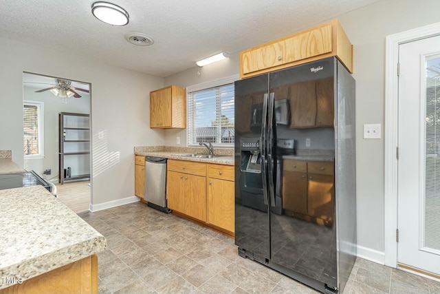 kitchen featuring black refrigerator with ice dispenser, dishwasher, a textured ceiling, and sink