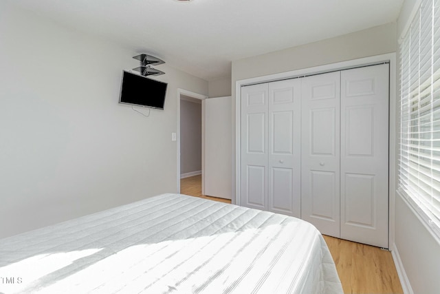 bedroom with light hardwood / wood-style floors and a closet