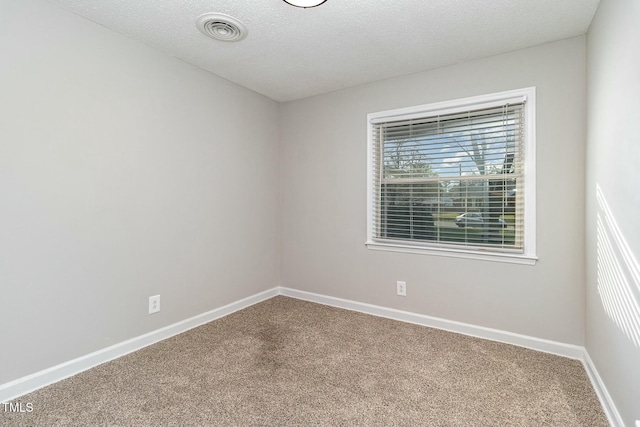 carpeted spare room with a textured ceiling