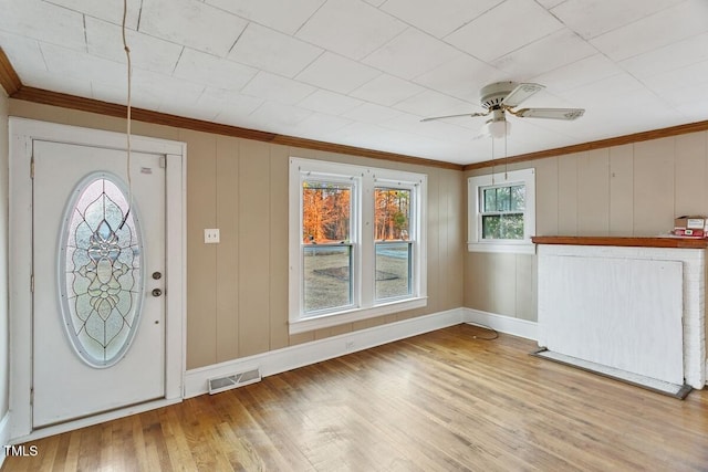 entryway with light hardwood / wood-style floors, ceiling fan, and ornamental molding