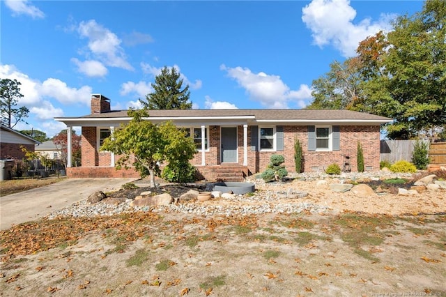single story home with brick siding, fence, and a chimney
