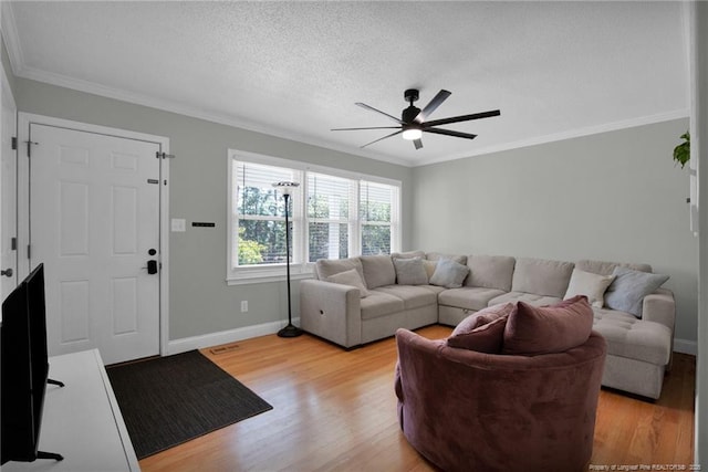 living room with a textured ceiling, ceiling fan, wood-type flooring, and ornamental molding