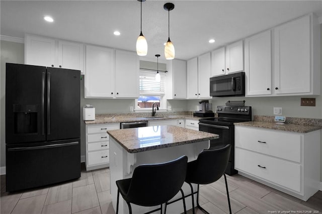 kitchen featuring pendant lighting, black appliances, white cabinets, sink, and a kitchen island