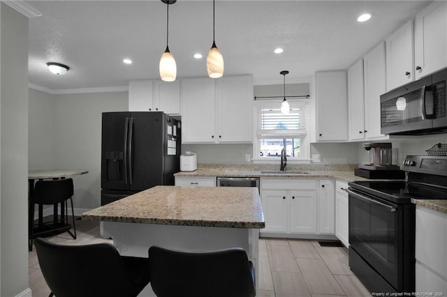 kitchen with white cabinets, sink, a center island, and black appliances