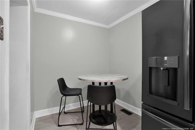 dining room with crown molding and a textured ceiling