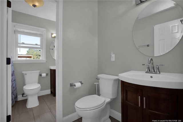 bathroom featuring tile patterned flooring, vanity, and toilet