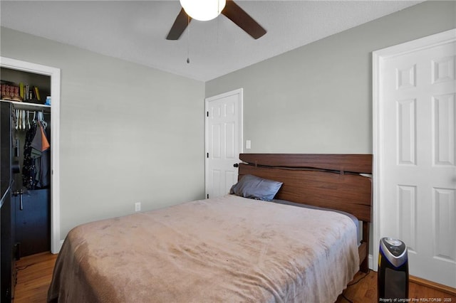 bedroom featuring hardwood / wood-style flooring, ceiling fan, and a closet