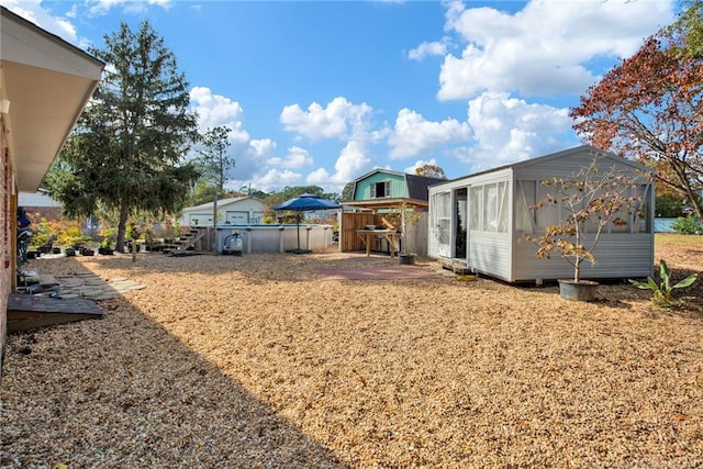 view of yard featuring a sunroom and a pool