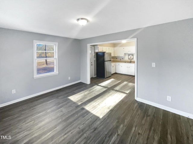 unfurnished living room featuring dark hardwood / wood-style flooring and sink