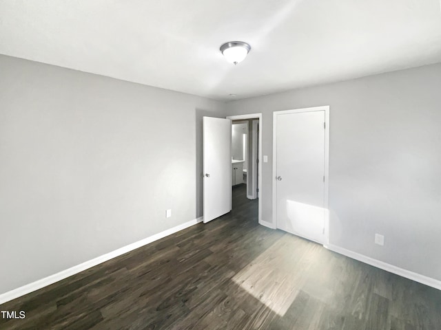 unfurnished bedroom with dark hardwood / wood-style floors