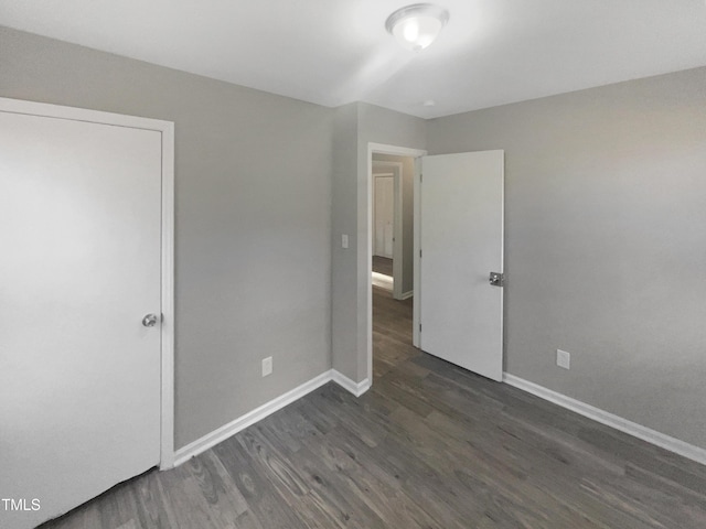 unfurnished bedroom with dark wood-type flooring