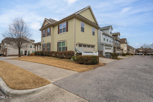 view of side of home featuring central AC unit and a garage