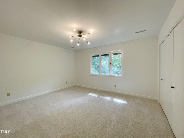 unfurnished bedroom with a closet, an inviting chandelier, and carpet flooring