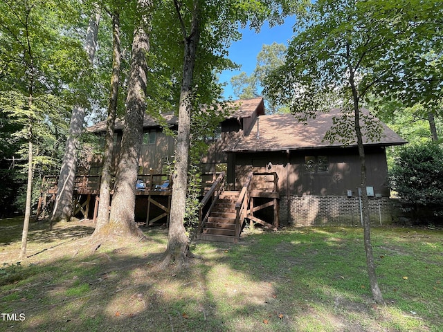 rear view of property with a deck and a yard