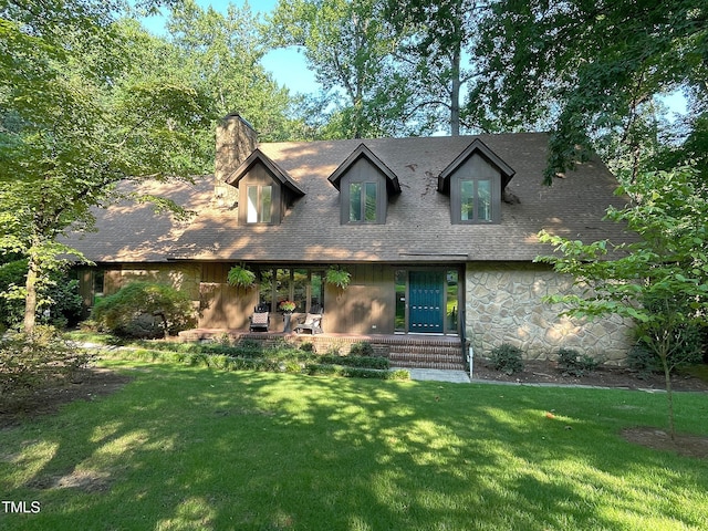 cape cod house featuring a front lawn and a patio