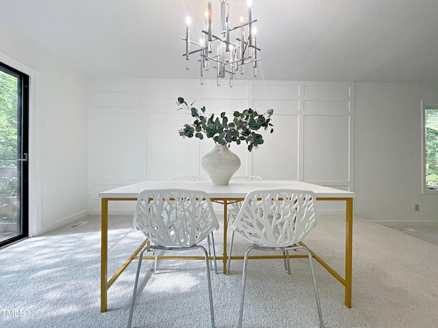 dining room with a chandelier and light colored carpet