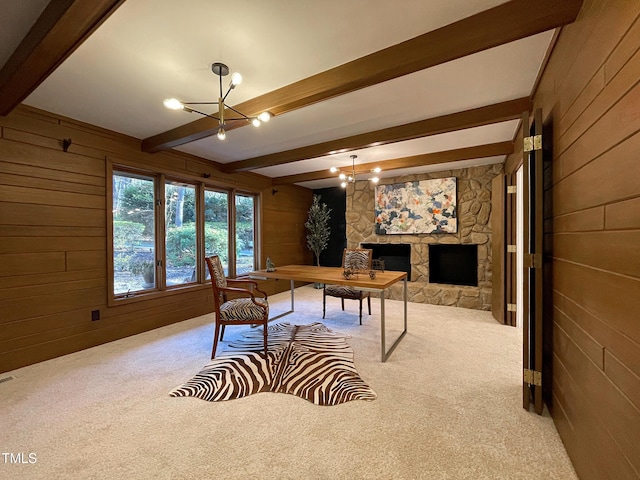 carpeted office space featuring wood walls, beam ceiling, a stone fireplace, and an inviting chandelier