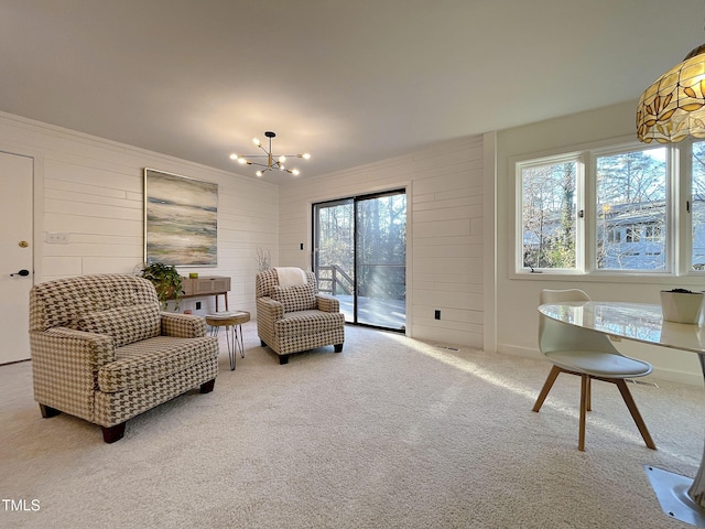 sitting room featuring light colored carpet, a notable chandelier, and wood walls