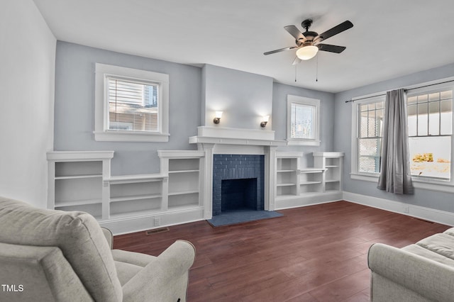 living room with dark hardwood / wood-style flooring, a brick fireplace, plenty of natural light, and ceiling fan