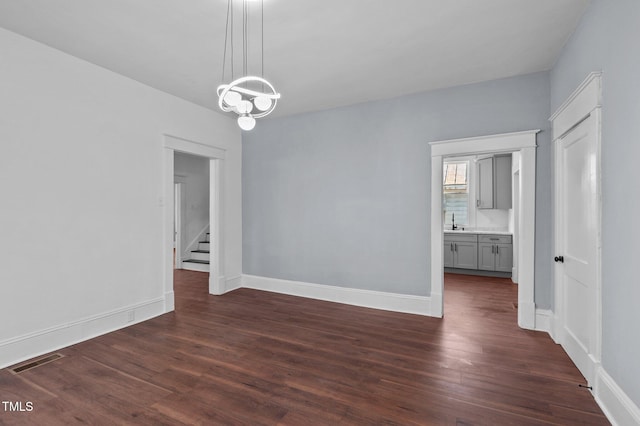 spare room featuring sink and dark hardwood / wood-style floors