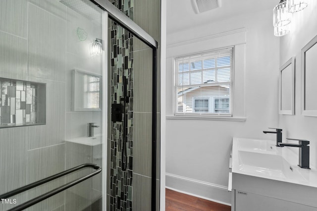 bathroom with wood-type flooring, vanity, and a shower with shower door