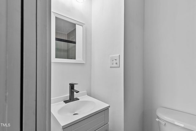 bathroom with vanity, toilet, and a shower