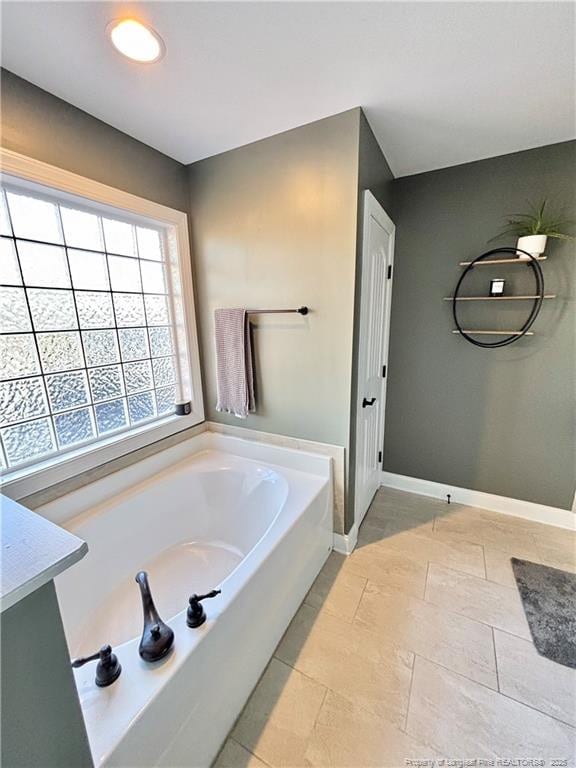 bathroom with a washtub and vanity