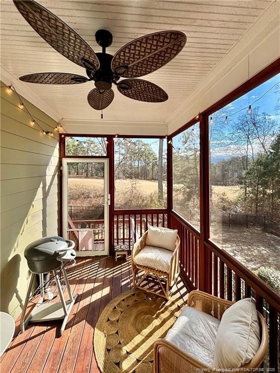 sunroom / solarium featuring ceiling fan and wood ceiling