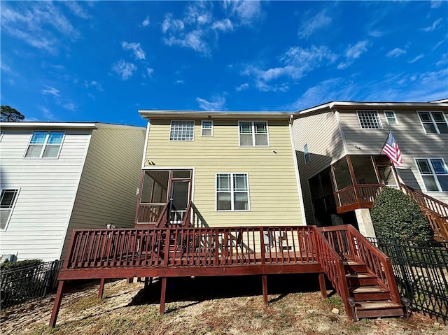 back of property with a wooden deck and a sunroom