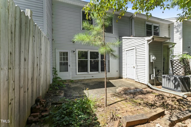 back of property with cooling unit and a patio