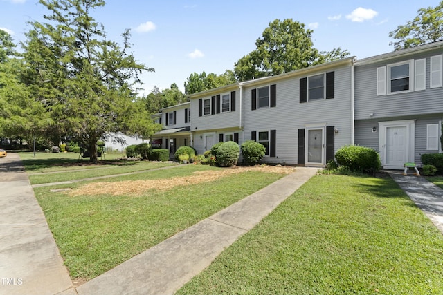 townhome / multi-family property with a front yard