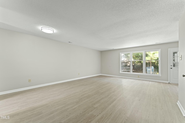 empty room featuring light hardwood / wood-style floors and a textured ceiling