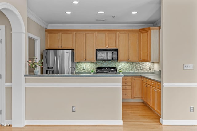 kitchen with decorative backsplash, crown molding, black appliances, and light wood-type flooring