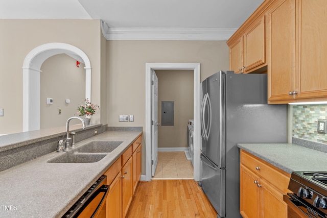 kitchen featuring tasteful backsplash, ornamental molding, black appliances, sink, and washing machine and clothes dryer