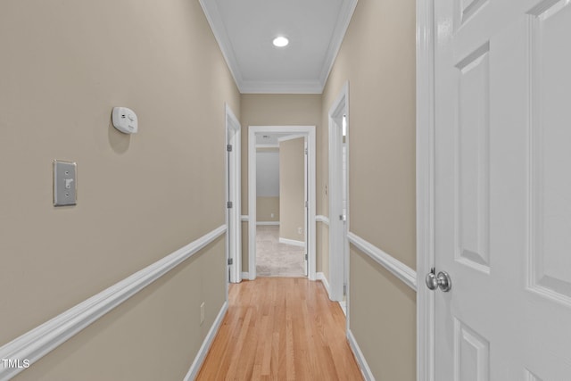 hall with light hardwood / wood-style floors and ornamental molding