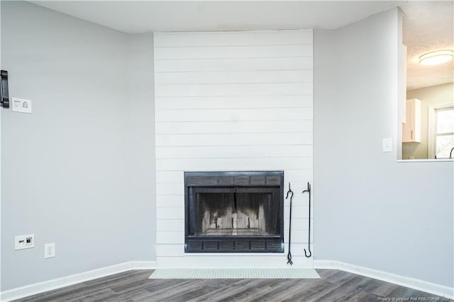 interior details with hardwood / wood-style floors and a large fireplace