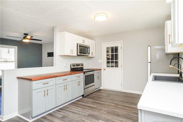 kitchen featuring decorative backsplash, stainless steel appliances, ceiling fan, sink, and white cabinetry